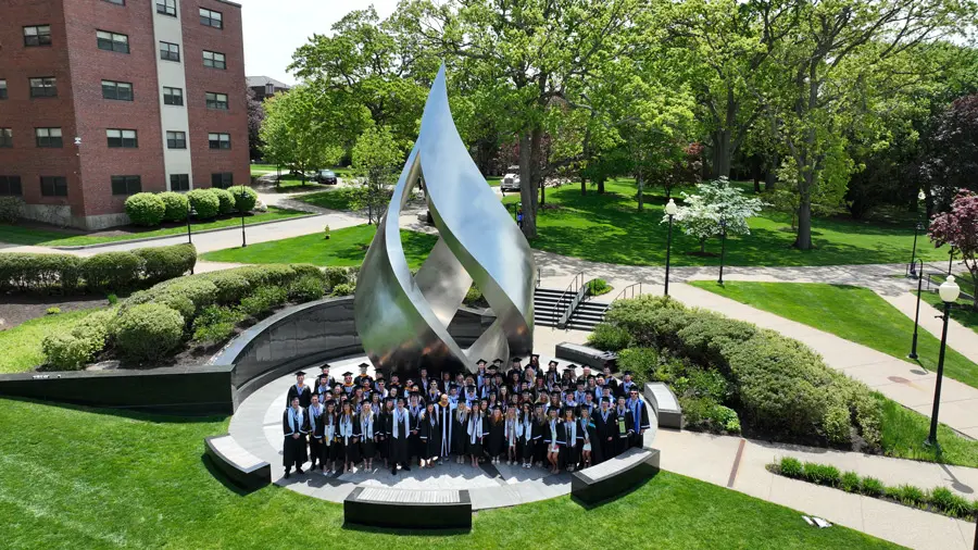 Graduates in front of flame statue